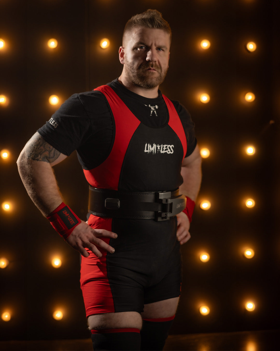 Person wearing a black and red outfit with 'Limitless' branding against a dark background with lights.