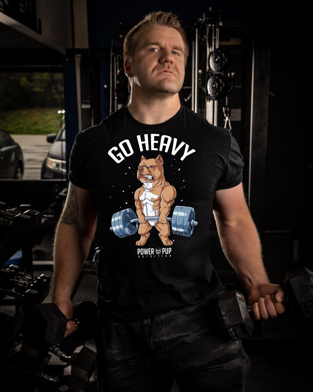 Man wearing a black t-shirt with a bear lifting weights graphic and text in a gym setting.