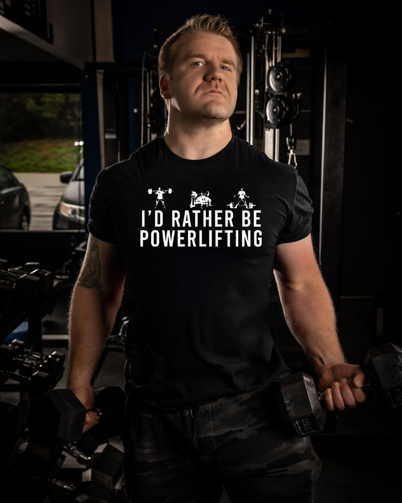 Man wearing a black t-shirt with 'I'd Rather Be Powerlifting' text in a gym setting