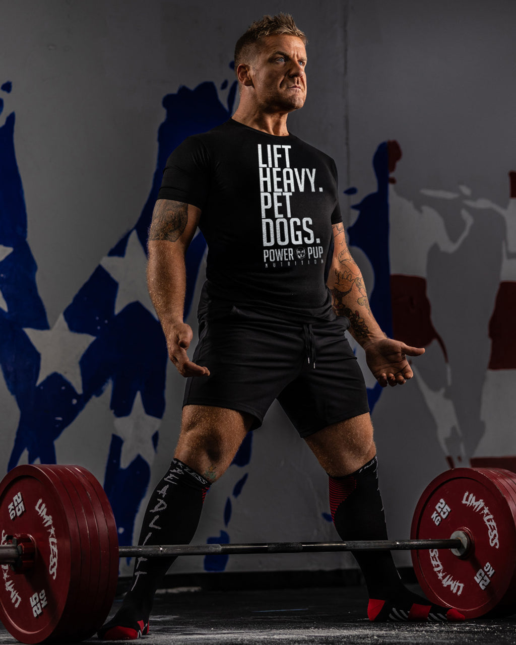 Man lifting weights with a motivational quote on his shirt against a colorful abstract background