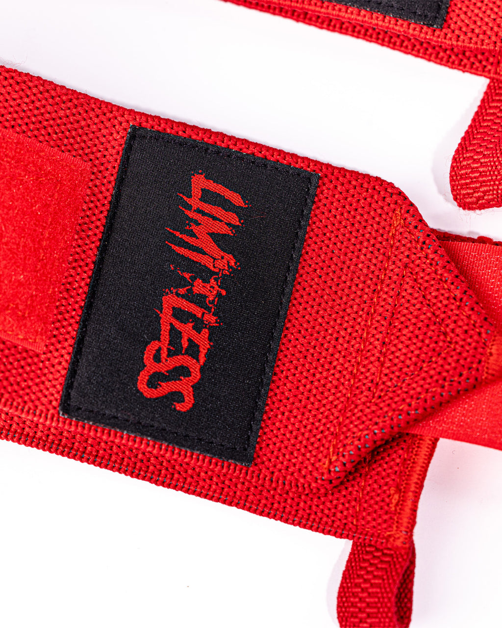 Limitless red wrist wraps with a black patch featuring red text on a white background