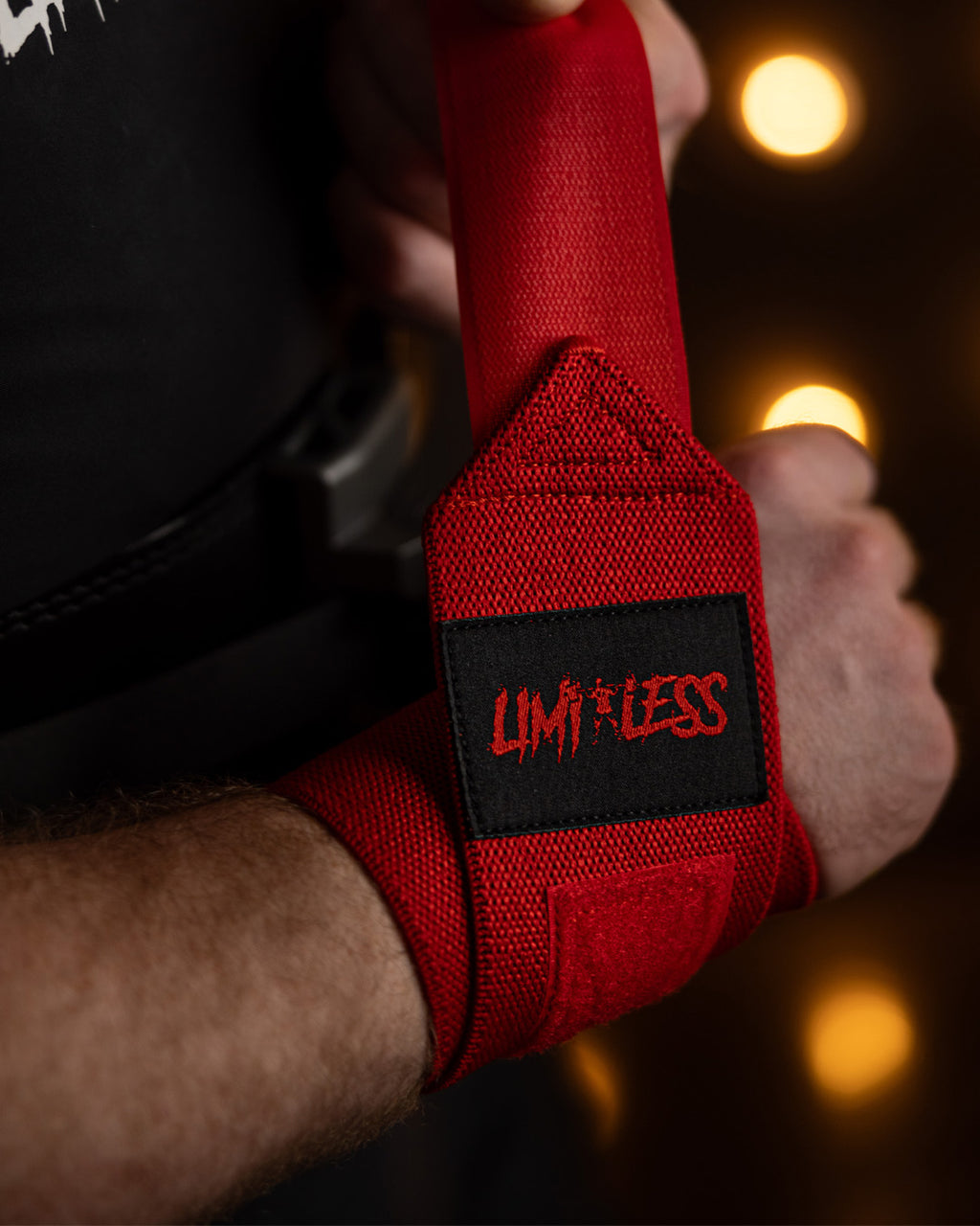 Red wrist wrap with 'Limitless' logo on a blurred background
