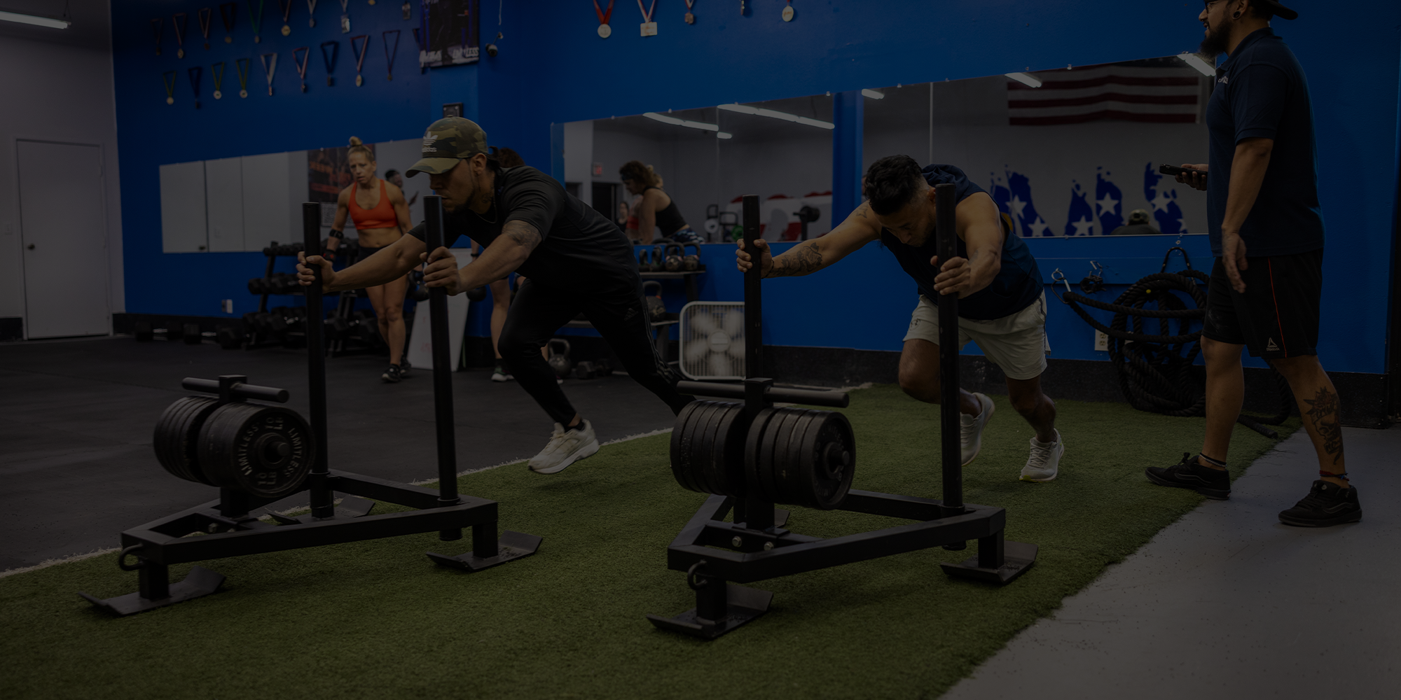 Two individuals using resistance training machines in a gym setting.