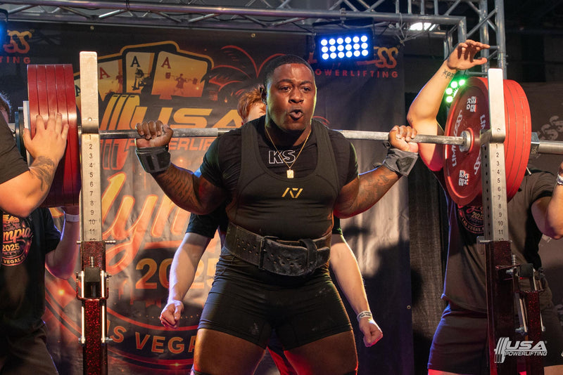 Athlete lifting a barbell at a powerlifting competition at USA Powerlifting Olympia Open hosted by Limitless Powerlifting.