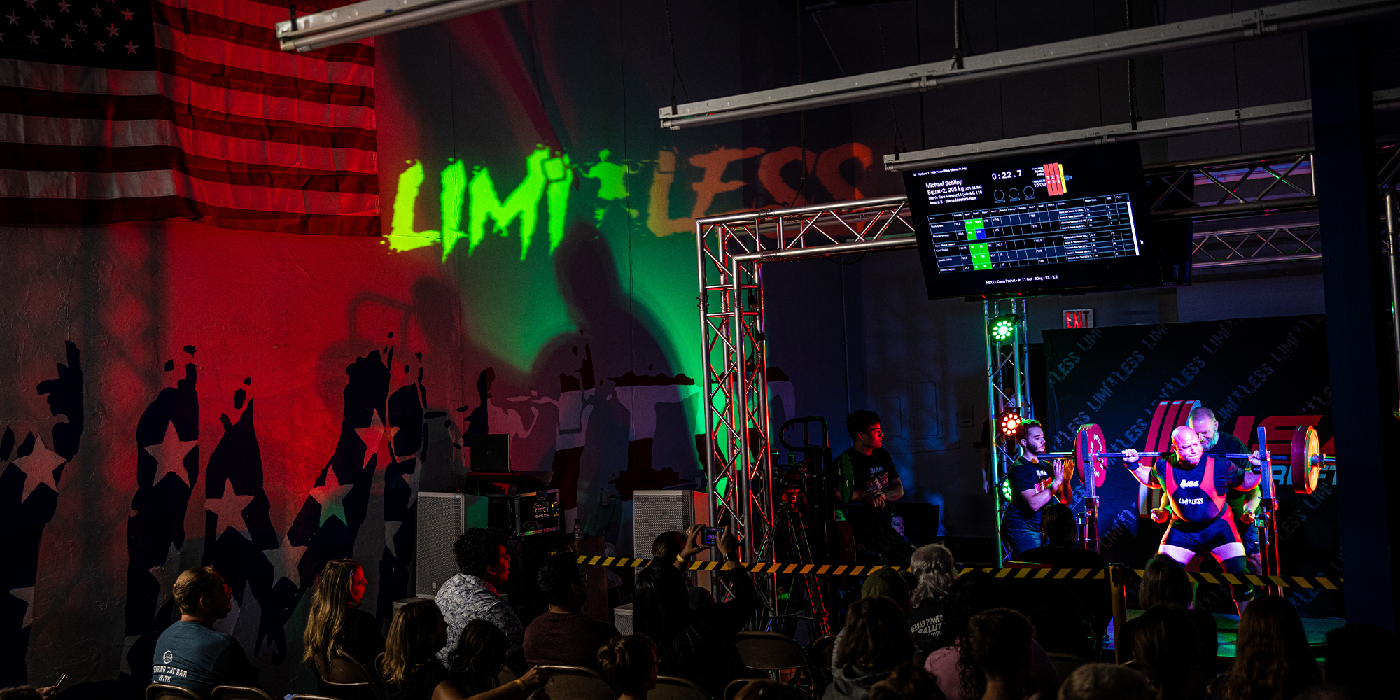 Event with 'Limitless' branding, stage setup, and audience in a darkened venue.
