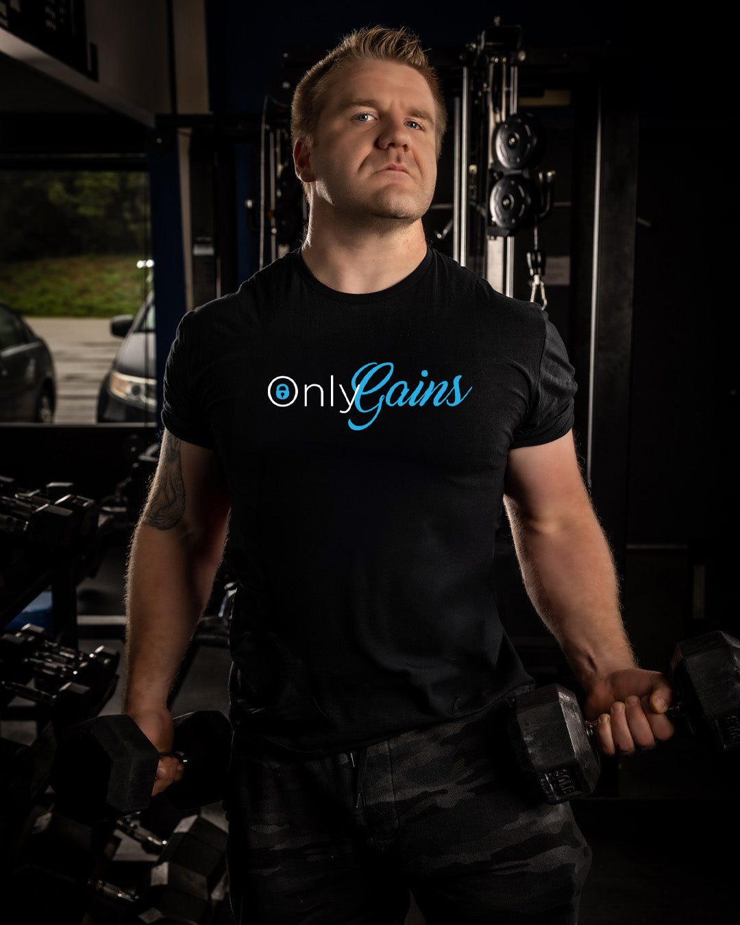 Man wearing a black t-shirt with 'Only Gains' text in a gym setting