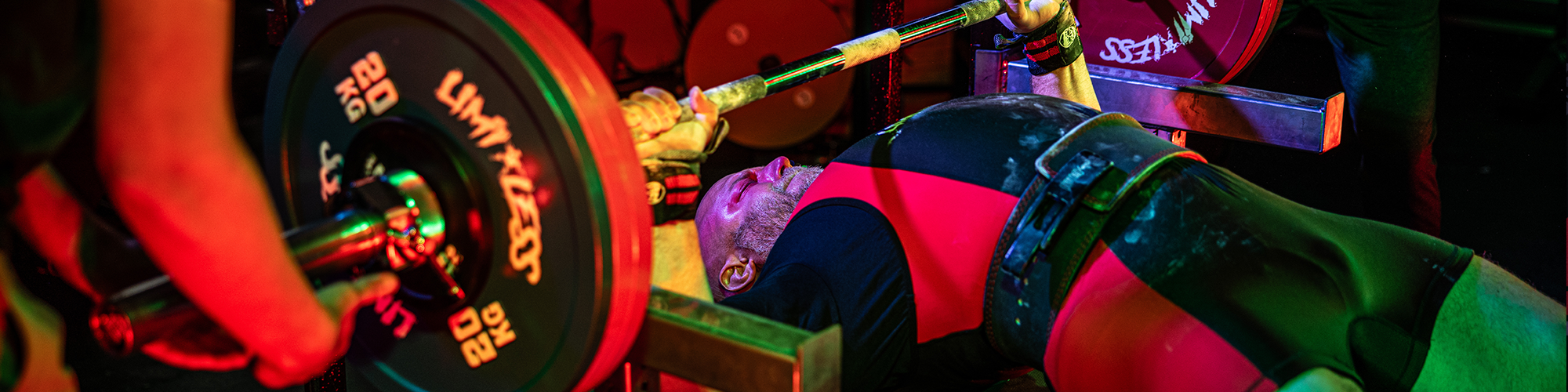 Person lifting Limitless weights with a barbell in a gym setting