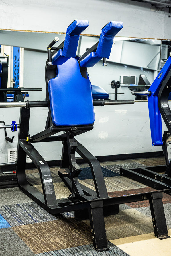 Blue lower-body machine next to mural