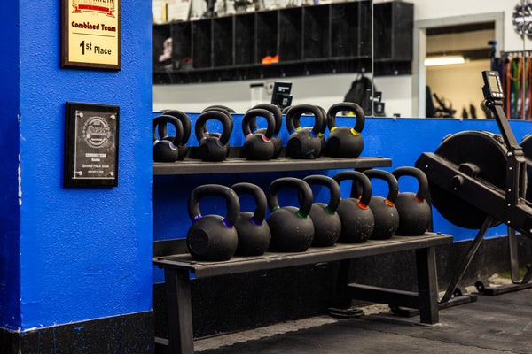 Dumbbells lined against blue accent wall in Limitless Elite Gym
